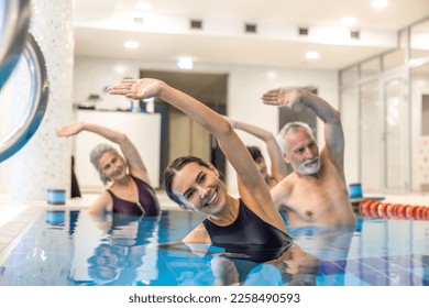 Senior adults in the swimming pool during aqua aerobics class - Powered by Shutterstock