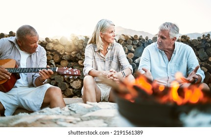 . Senior, Adventure And Fun Wellness Hiking Group Of Friends, Relaxing Or Taking A Break By The Campfire After Walking On Outdoors Mountain Trip. Elderly Explorers Resting On Camping Getaway Trip.