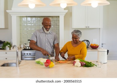 Senior African American Couple Cooking Together In Kitchen Smiling. Retreat, Retirement And Happy Senior Lifestyle Concept.