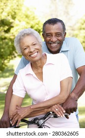 Senior African American Couple Cycling In Park