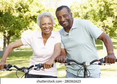 Senior African American Couple Cycling In Park