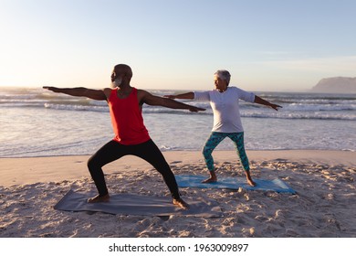 Senior african american couple performing stretching exercise together at the beach. fitness yoga and healthy lifestyle concept - Powered by Shutterstock