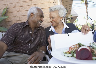 Senior African American Couple Sitting In Restaurant After Shopping