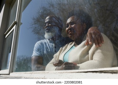 Senior african american couple spending time at home together, looking through window. isolating during coronavirus covid 19 quarantine lockdown. - Powered by Shutterstock