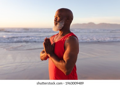 Senior african american man with folded hands meditating and practicing yoga at the beach. fitness yoga and healthy lifestyle concept - Powered by Shutterstock