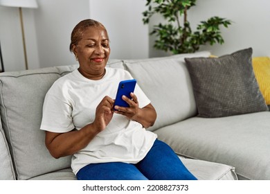 Senior african american woman smiling confident using smartphone at home - Powered by Shutterstock