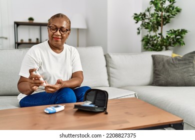 Senior african american woman smiling confident measuring glucose at home - Powered by Shutterstock