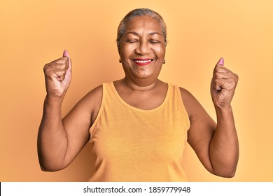 Senior african american woman wearing casual style with sleeveless shirt celebrating surprised and amazed for success with arms raised and eyes closed  - Powered by Shutterstock