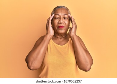 Senior african american woman wearing casual style with sleeveless shirt with hand on head, headache because stress. suffering migraine.  - Powered by Shutterstock