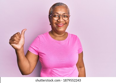 Senior african american woman wearing casual clothes and glasses smiling happy and positive, thumb up doing excellent and approval sign 