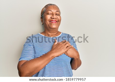 Senior african american woman wearing casual clothes smiling with hands on chest, eyes closed with grateful gesture on face. health concept. 