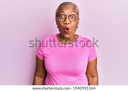 Senior african american woman wearing casual clothes and glasses scared and amazed with open mouth for surprise, disbelief face 