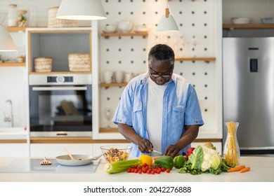 Senior African Man Standing In The Kitchen And Preparing A Healthy Dinner.