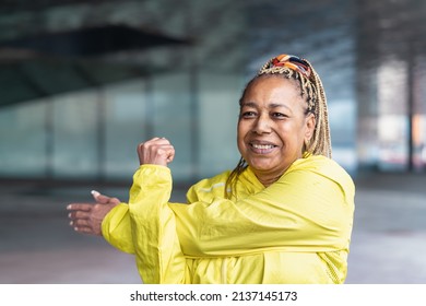 Senior African woman doing stretching before run in the city - Elderly Sporty people lifestyle concept - Powered by Shutterstock