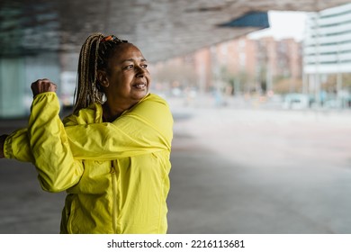 Senior African woman doing warm up exercises outdoor - Elderly Sporty people lifestyle concept - Powered by Shutterstock