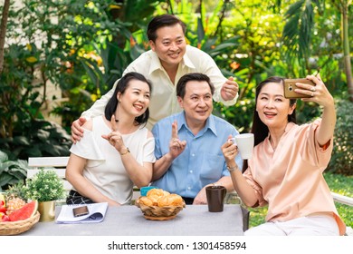 Senior afternoon tea. Asian senior people having a afternoon tea party in outdoor garden, taking selfie. Senior lifestyle concept. - Powered by Shutterstock