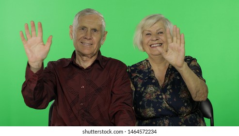 Senior aged man and woman waving with hands to camera on chroma key background. Concept of a happy family in old age.  - Powered by Shutterstock