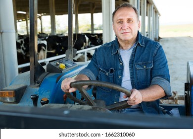 Senior Aged Man Working On Small Farm Tractor