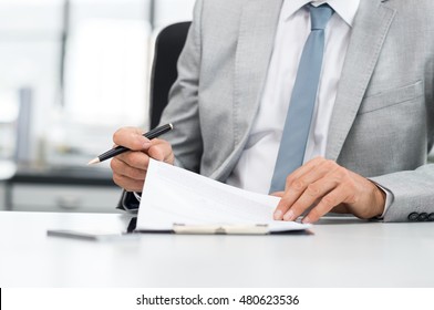 Senior Analyst Managing Business Accounts. Close Up Of A Senior Businessman Hands Checking Final Report Before Submission. Close Up Of Hands Of Leadership Signing Business Contract.