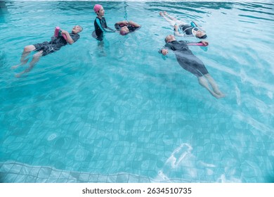 senior aquatic class practicing water relaxation and float techniques. Participants float with support, guided by an instructor in a serene pool, promoting wellness and calmness through water therapy.