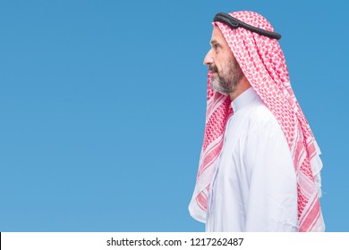 Senior Arab Man Wearing Keffiyeh Over Isolated Background Looking To Side, Relax Profile Pose With Natural Face With Confident Smile.