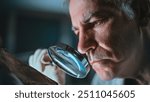 Senior archaeologist studies remains of prehistoric extinct animal or human using magnifying glass. Scientist works with fossils, does historical bone examination in archaeological laboratory at night