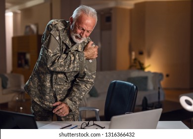 Senior Army Solider Experiencing Pain In Shoulder While Working In The Office. 