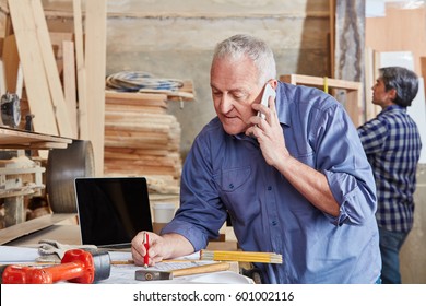 Senior Artisan Calling On The Phone At His Carpentry Workshop