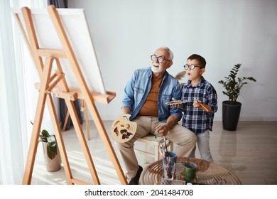 Senior artist and his grandson admire their painting which they painted in the home studio - Powered by Shutterstock