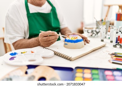 Senior artist man painting pottery sitting on the table at art studio. - Powered by Shutterstock