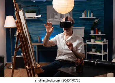 Senior Artist Using Vr Glasses For Virtual Inspiration At Art Studio. Caucasian Old Person With Technology Working On Professional Masterpiece With Modern Headset In Workshop Room