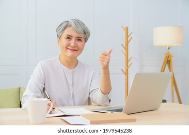 Senior Asia Woman Working From Home Using Laptop And Smart Phone. Old Woman Living And Learning Online.