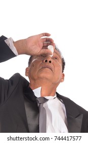 Senior Asian Businessman Getting The Medicine In The Eye. Older Man Applying Eye Drops Isolated On White Background.  Man Has A Cataract In His  Eyes. Health Care Concept.