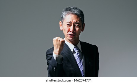 Senior asian businessman showing a fist pump.