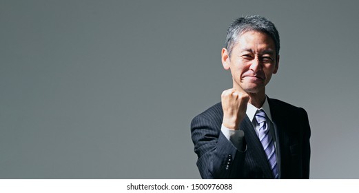 Senior asian businessman showing a fist pump. - Shutterstock ID 1500976088