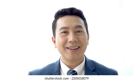 Senior Asian Businessman Speaking To The Camera While Making An Online Video Conference. Business Man Smiling To Camera Close Up.