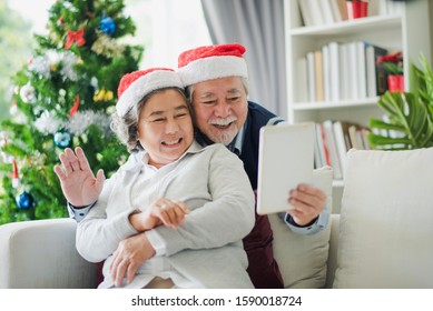 Senior Asian couple family celebration in Christmas day, Retired man and woman using tablet to video call with young family smile felling happy in living room at home. Merry Xmas and happy new year. - Powered by Shutterstock