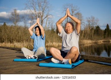 A Senior Asian Couple Meditating And Practicing Yoga