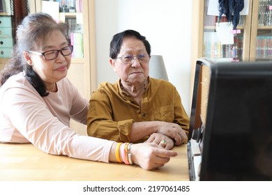 The Senior Asian Couple Trying To Listen Music From The Vintage Radio.