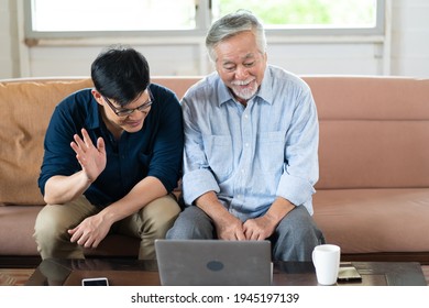 Senior Asian Father And Adult Grown Son Having Video Call On Laptop Computer. 