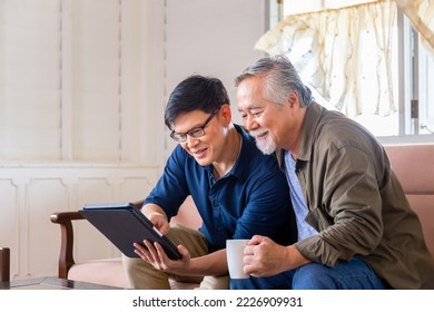 Senior Asian father and adult son using tablet smartphone in living room, Happiness Asian family concepts - Powered by Shutterstock