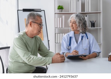 Senior Asian female doctor talking and counseling with an elderly male patient. - Powered by Shutterstock