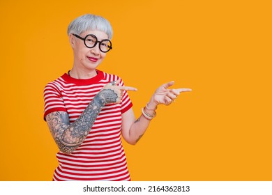 Senior Asian Female Grey Hair Fashioned Cloth With Tattoo Arm Standing Hand Gesture With Positive Confident Expression,old Asia Woman Wear Red Tshirt Carefree Lifestyle Happiness Pension Age 