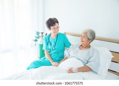 Senior Asian Female Patient Smiling With Nurse Who Come To Visit Her At Bed