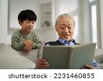 senior asian grandfather having a good time with grandson at home
