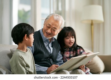 senior asian grandfather having a good time with two grandchildren at home - Powered by Shutterstock