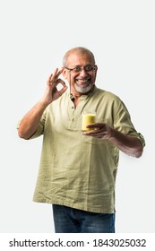 Senior Asian Indian Man Holding Or Drinking Turmeric Milk In A Glass -Healthy Eating Concept