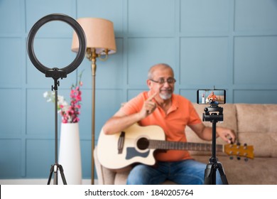 Senior Asian Indian Musician Performing While Taking Online Music Class Or Recording Video On Smartphone