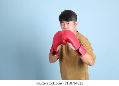 The Senior Asian Man With Casual Clothes Standing On The Blue Background.