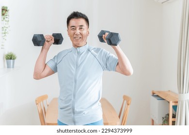 Senior Asian man doing strength training with dumbbells - Powered by Shutterstock